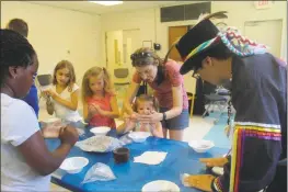  ??  ?? On July 18, Crystal Proctor, executive director of Living the American Indian Experience (LAIE), taught the children how to make American Indian clay pots at the La Plata Library. The Piscataway women used to make big clay pots, put them in the fire, and once dry, the pot would be used to store necessitie­s like wheat or grain.