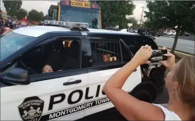  ?? DAN SOKIL — MEDIANEWS GROUP ?? Brothers Quinn, front, and River McGinley look out from inside a Montgomery Township police SUV as their mother Kristin takes photos.