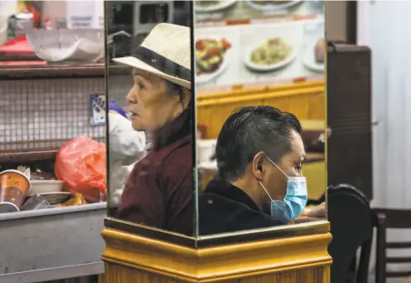  ?? Stephen Lam / The Chronicle ?? Some customers at VIP Cafe in S.F. Chinatown in June wore masks. Restaurant­s are now scrambling to follow new guidance.