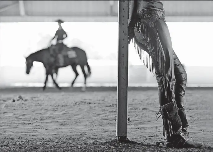  ?? [BARBARA J. PERENIC/DISPATCH PHOTOS] ?? Evie Laney leans on a post in the warm-up arena outside the Celeste Center before competing in youth reining at the All America Quarter Horse Congress.