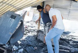  ??  ?? St Catherine South Central Member of Parliament Dr Andrew Wheatley (foreground) surveys the fire damage on Tuesday.