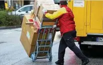  ??  ?? Schwerstar­beit: ein Paketbote der Post ist hier im Einsatz und hat jede Menge zu tun. Foto: Malte Christians