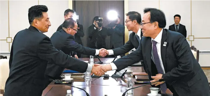  ??  ?? En segundo plano, el director de la delegación de Corea del Norte, Jon Jong Su (izq), saluda a su homólogo de Corea del Sur, Chun Hae-sung