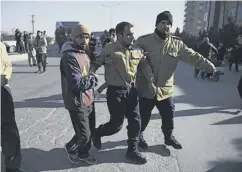  ??  ?? 0 Afghan security staff assist an injured colleague near the hotel