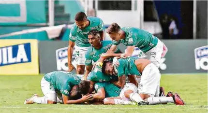  ?? DIMAYOR ?? Los jugadores verdiblanc­os celebra el tanto de la victoria, marcado en el último minuto ante un compacto y duro La Equidad.