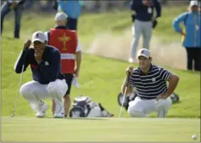  ?? MATT DUNHAM - THE ASSOCIATED PRESS ?? Tiger Woods of the US, left, and Patrick Reed of the US line up a putt during their fourball match on the opening day of the 42nd Ryder Cup at Le Golf National in Saint-Quentin-enYvelines, outside Paris, France, Friday, Sept. 28, 2018.