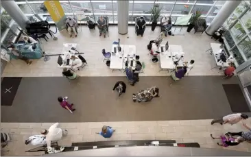  ?? The Maui News / MATTHEW THAYER photo ?? Health workers administer vaccines in the lobby of Maui Memorial Medical Center in January. Vaccine clinics statewide expanded eligibilit­y on Monday to Phase 1c, the largest group under the state’s vaccinatio­n plan.