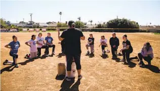  ?? ARIANA DREHSLER PHOTOS ?? Coach Mindee Anderson talks to players in the Clairemont Girls Fastpitch league after practice Saturday at the East Clairemont Athletic Fields.