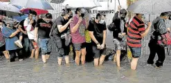  ?? —INQUIRER FILE PHOTO ?? People fall in line despite the flood outside a vaccinatio­n site in Manila.