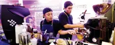  ?? — Bernama photo ?? Muhammad Hafizi (left) and friend Muhammad Hafif Alifie Mohd Mazni prepare drinks ordered by visitors at the Central Zone Madani Rakyat Programme.