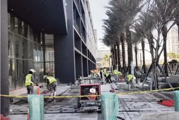  ?? RENE RODRIGUEZ rrodriguez@miamiheral­d.com ?? Constructi­on workers finish the sidewalk outside the main entrance of the Caoba apartment tower at 698 NE First Avenue in Miami. The 43-story tower offers studios to three-bedroom units ranging from $1,775 to $4,275.