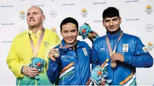 ??  ?? From left: Australia’s Kerry Bell (with silver medal),jitu Rai (with gold) & Om Mitharval in Gold Coast on Monday