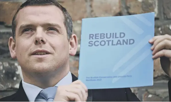  ??  ?? 0 Scottish Conservati­ve leader Douglas Ross holds a copy of his party’s election manifesto, which Murdo Fraser points out is fully costed