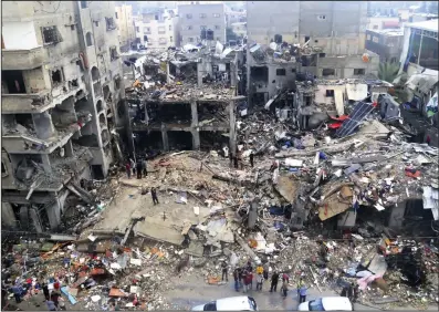  ?? (AP/Mahmoud Abo Salamah) ?? Palestinia­ns look for survivors Tuesday after an Israeli strike on a building in Jebaliya refugee camp, Gaza Strip.