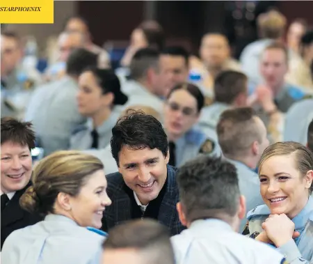  ?? MICHAEL BELL / THE CANADIAN PRESS ?? Prime Minister Justin Trudeau, seen with RCMP cadets in Regina, is reportedly looking for a qualified woman to lead the troubled police force.