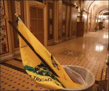  ?? (For The Washington Post/Oliver Contreras) ?? A Gadsden flag sits in a trash can at the U.S. Capitol, left by pro-Trump protesters who stormed it on Jan. 6, 2021. The flag and the Confederat­e battle flag flew together in the riot.