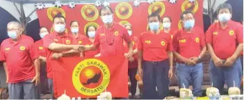  ??  ?? Baru (right) hands over a PSB flag to PSB Trusan Laut branch chairman Robert Tai during the gathering, witnessed by supporters.