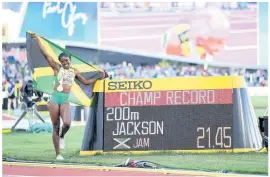  ?? ?? Jackson poses by the clock displaying her championsh­ip record of 21.45 seconds, the second fastest time in history.