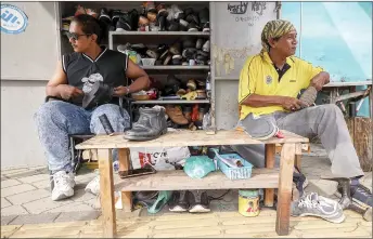  ?? — Bernama photo ?? Muhammad Adam (left) with his father Muhammad Ali, 63, doing their daily routine of cobbling shoes at the Kuantan Art Street.