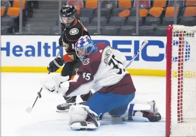  ?? KYUSUNG GONG – THE ASSOCIATED PRESS ?? Ducks center Adam Henrique, left, tries to deflect the puck in front of Avalanche goalie Jonas Johansson on Sunday at Honda Center.