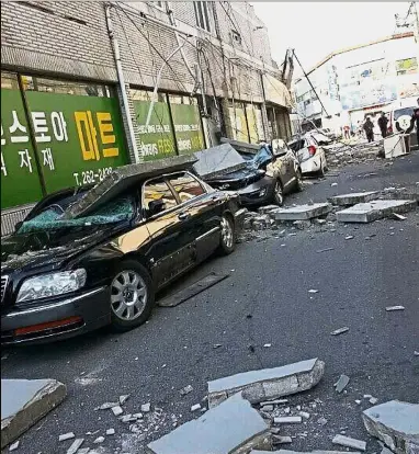  ??  ?? Temblor
damage: Cars parked in front of a shopping centre are damaged by falling debris after the earthquake in Pohang.
— AP