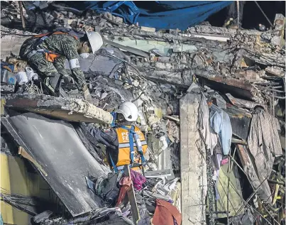  ?? Pictures: Getty. ?? Rescuers break or remove slabs until they find a crack through which they can wriggle in order to reach people and lift them to safety.