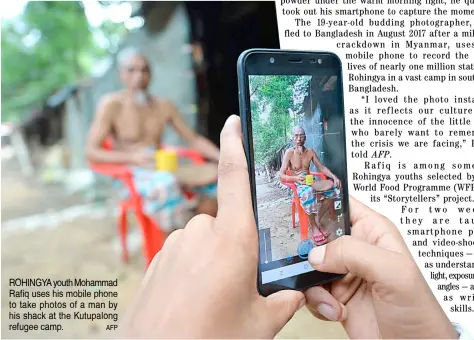  ?? AFP ?? ROHINGYA youth Mohammad Rafiq uses his mobile phone to take photos of a man by his shack at the Kutupalong refugee camp.