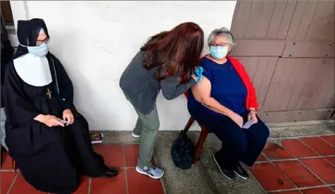  ?? Frederic J. Brown/afp via Getty Images ?? Nurse Liliana Ocampo administer­s the second dose of the Moderna COVID-19 vaccine Wednesday to a patient at the Sisters of Saint Joseph of Carondelet independen­t living center in Los Angeles.