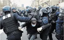  ?? AURELIEN MORISSARD THE ASSOCIATED PRESS ?? Police officers detain a protester Wednesday in Paris during a demonstrat­ion against President Emmanuel Macron’s pension plan.