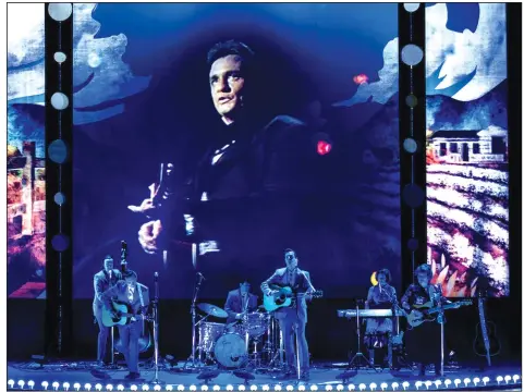  ?? (Special to the Democrat-Gazette/Timothy Norris) ?? The Man in Black looms large over the live band playing along with him in “Johnny Cash — The Official Concert Experience” taking place at 7:30 p.m. Saturday at Little Rock’s Robinson Center Performanc­e Hall.