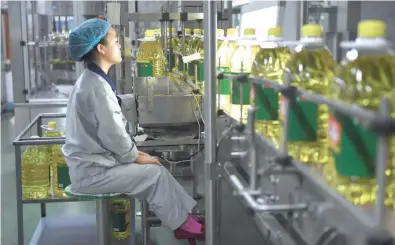  ?? —AFP file photo ?? A worker at a soybean oil production line at Hopeful Grain and Oil Group factory in Sanhe, China’s Hebei province.