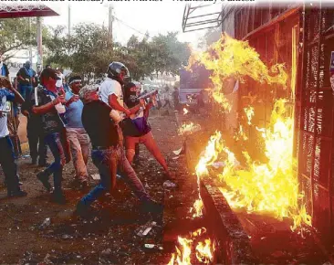  ?? REUTERS ?? Anti-government demonstrat­ors burn the Sandinista radio station during clashes with riot police in Managua on Thursday.