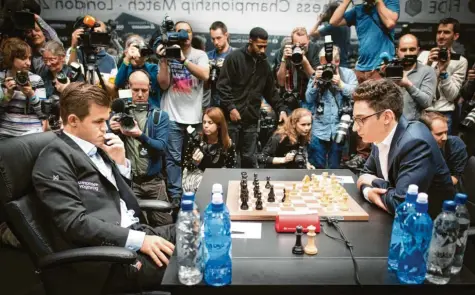  ?? Foto: dpa ?? Ein kurzes Schauspiel: Nur anfangs dürfen Journalist­en und Fotografen in das Zimmer, in dem sich der Norweger Magnus Carlsen (links) und Fabiano Caruana aus den USA packende, aber geräuschlo­se Endspiele liefern. Jede der bisherigen acht Begegnunge­n endete unentschie­den.