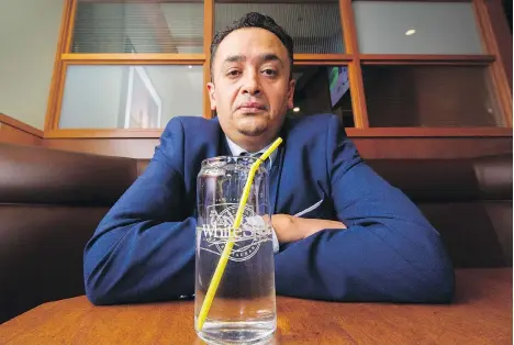  ?? ARLEN REDEKOP ?? White Spot general manager Naseer Khwaja sits with a drink inside his Vancouver restaurant on Monday. The burger chain gives customers straws for their drinks only upon request, and company president Warren Erhart says they are testing paper straws as...