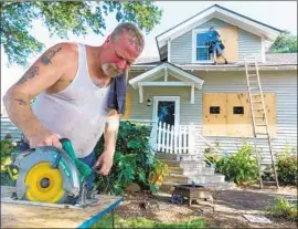  ?? Robert Gourley For The Times ?? IN BEAUFORT, N.C., Willy Cortright cuts plywood to board up windows. He said he planned to ride out the powerful hurricane, due to make landfall by Saturday.