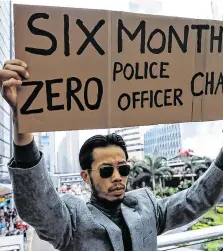  ??  ?? A man holds a placard as anti-government office workers attend a lunch time protest in Hong Kong