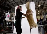  ?? MATT YORK / ASSOCIATED PRESS ?? Samantha Estes prepares garments to be photograph­ed at the ThredUp sorting facility in Phoenix.