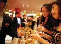  ?? FOTO: CARLOS BARRIA ?? Vestlige luksusmerk­er vokser i det asiatiske markedet. Her er en dame i aksjon på Louis Vuittons butikk i Shanghai.