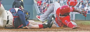  ?? JIM MONE/ASSOCIATED PRESS ?? The Angels' Justin Upton, right, is tagged out at the plate by Twins catcher Bobby Wilson during the eighth inning Saturday in Minneapoli­s. The Angels won 2-1.