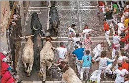  ?? PABLO BLAZQUEZ DOMINGUEZ/GETTY ?? in the traditiona­l running of the bulls in Pamplona, Spain, on Saturday, the second day of the annual San Fermin festival. Authoritie­s said a man who was gored by a bull and three other men who were trampled were hospitaliz­ed.