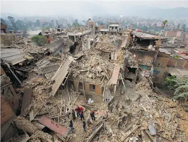  ?? NIRANJAN SHRESTHA/The Associated Press ?? Rescue workers remove debris as they search for victims of an earthquake in Bhaktapur near Kathmandu, Nepal on Sunday. A strong earthquake shook Nepal’s capital and the densely populated Kathmandu Valley before noon Saturday,
causing extensive damage...