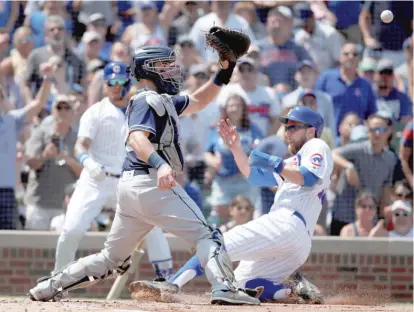  ?? AP ?? Padres catcher Austin Hedges reaches for the ball as Cubs baserunner Ben Zobrist slides home safely in the second inning.