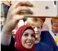  ?? AFP ?? A syrian refugee poses for a selfie photo with German Chancellor Angela Merkel as she continued on the poll campaign trail in Stralsund. —