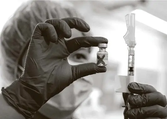  ?? Photos by Kin Man Hui / Staff photograph­er ?? Pharmacy technician Vernice Ver displays the 100,000th dose of the Pfizer vaccine as University Health reaches a milestone in fighting the COVID-19 pandemic.