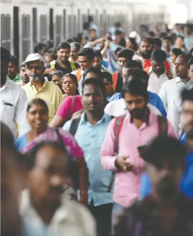  ?? ARUN SANKAR / AFP / GETTY IMAGES FILES ?? Indian commuters make their way through a central railway station at rush hour on World Population Day in
Chennai on July 11 last year. The day is observed to help increase awareness of global population issues.