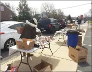  ?? EVAN BRANDT — MEDIANEWS GROUP ?? After running out of the pre-sorted meals Wednesday, Pottstown schools officials improvised and set up tables to allow families to sort their own supplies.