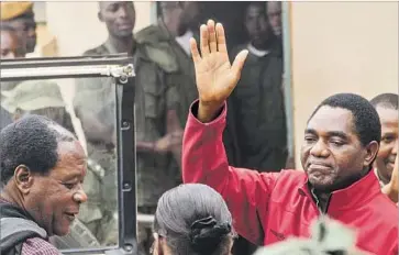  ?? Dawood Salim AFP/Getty Images ?? ZAMBIAN opposition leader Hakainde Hichilema waves to supporters as he leaves a courtroom in Lusaka last month. Observers see Hichilema’s arrest as part of a troubling trend in several nations in sub-Saharan Africa.