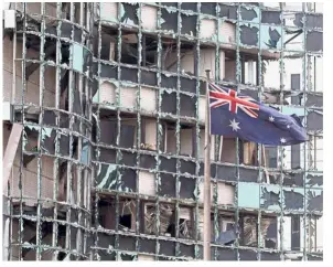  ??  ?? Violence on foreign soil: ( Top) An Australian flag flying near a damaged building following a blast outside the Australian Embassy in Jakarta on Sept 9, 2004. (Right) An aerial view showing the site of the bombing of the US Embassy building in Nairobi on Aug 7, 1998. (Bottom right) A gunman pointing his AK-47 rifle at photograph­ers as he guards a group of hostages inside the Myanmar Embassy during a siege in Bangkok in 1999. — Agencies