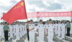  ?? — Reuters ?? A soldier of China’s People’s Liberation Army is holding a PLA flag as others stand guard at a military port in Zhanjiang, Guangdong province.