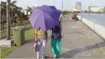  ?? — AFP ?? A couple walks in the Inya Lake Park in Yangon on Wednesday.